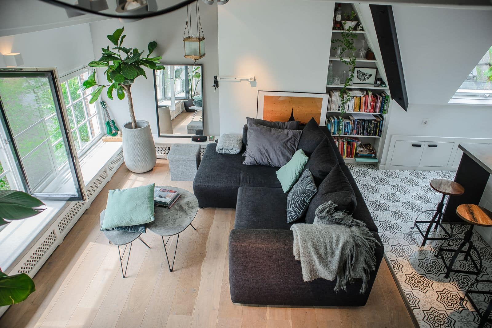 Bright apartment living room with a sofa, plants and open windows