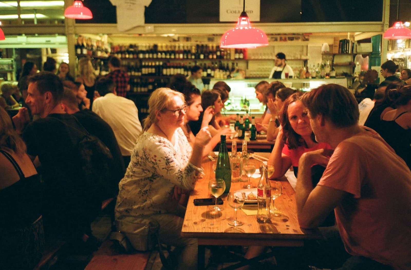 Restaurante cheio ao fim do dia, com clientes a jantar em mesas de madeira